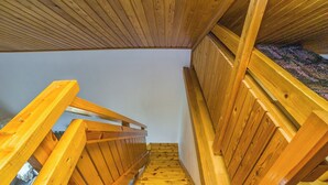 Eine Holztreppe mit Handlauf, die nach oben führt.
