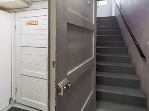 Una puerta cerrada con un letrero que dice 'suna' y una escalera con barandilla.