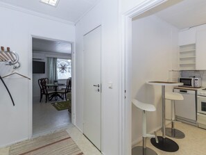 A compact kitchen with a microwave, oven, and a small dining area with chairs and a table.