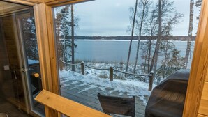 A wooden deck with a view of a lake and trees.
