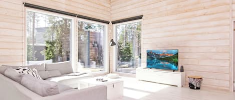 Un salon moderne avec un canapé, un téléviseur et une table basse.