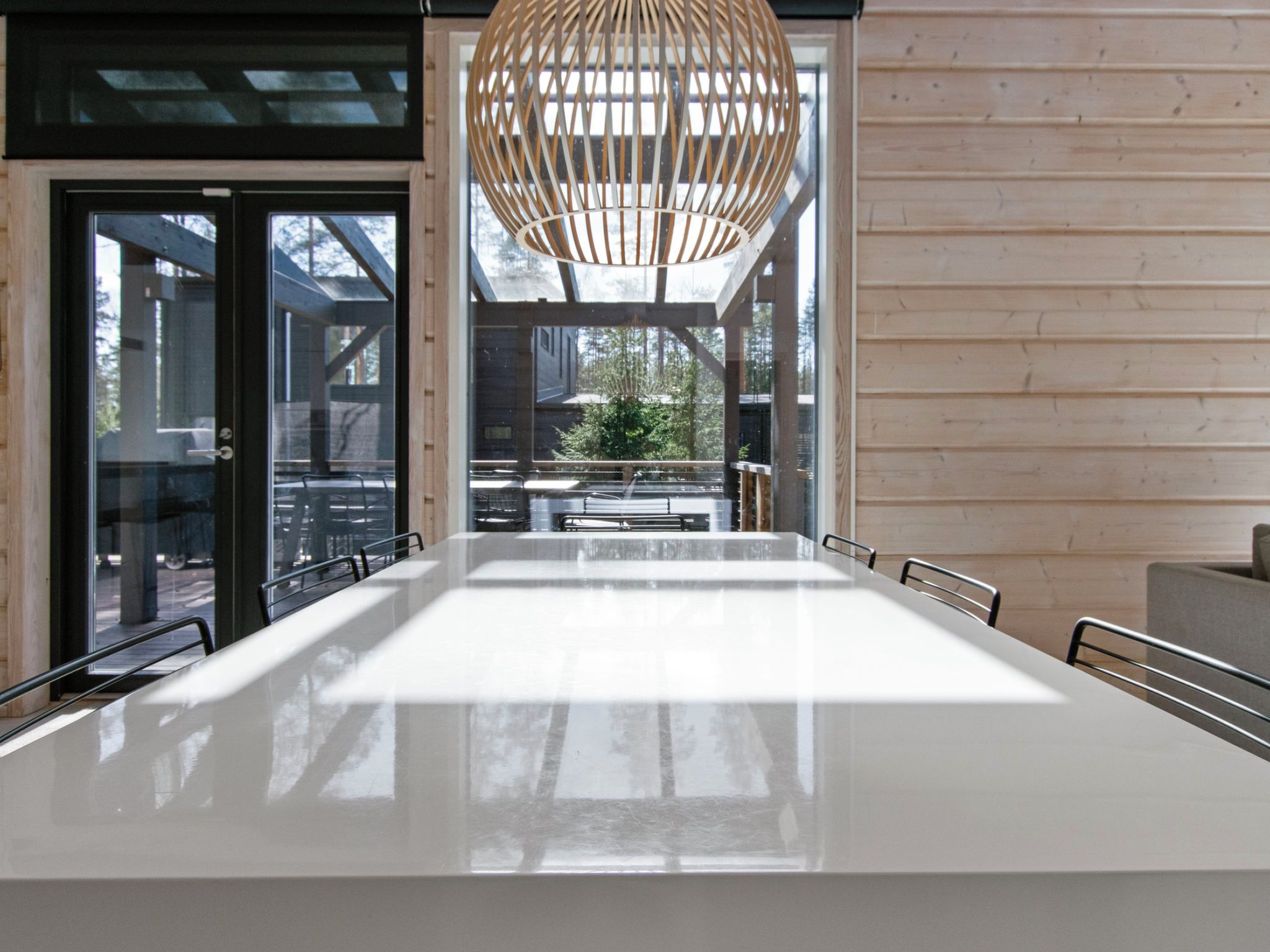 Un comedor moderno con una mesa larga, sillas y una lámpara colgante original.