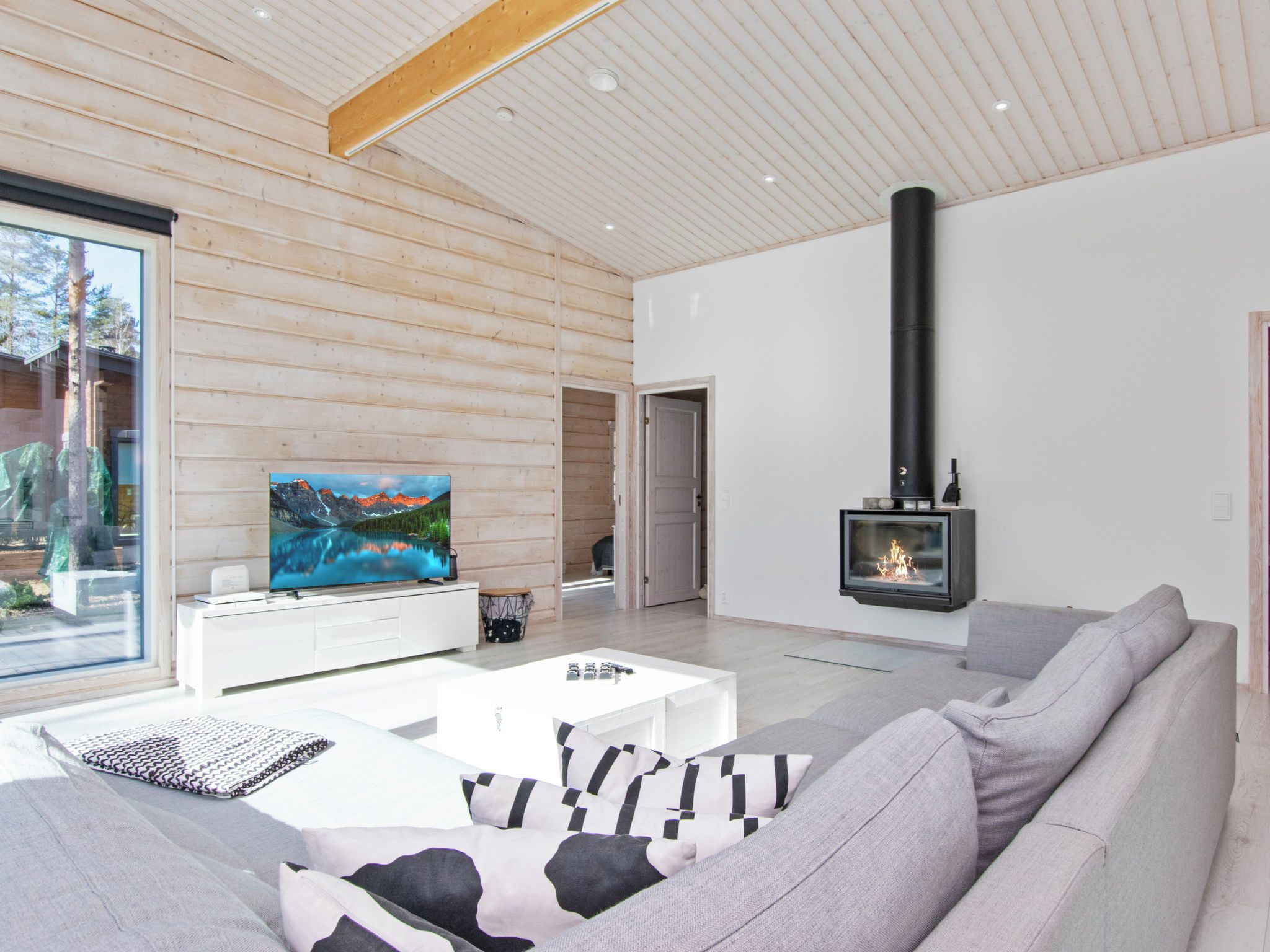 Ein modernes Wohnzimmer mit Fernseher, Kamin und einer Couch.