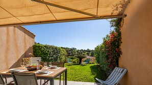 Eine Terrassengruppe mit Esstisch, Stühlen und Sonnenschirm.