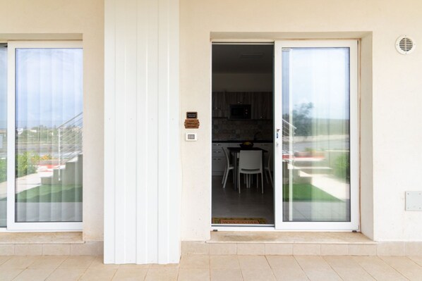 Un apartamento moderno con un cerramiento de vidrio corredera que da a una cocina y comedor.