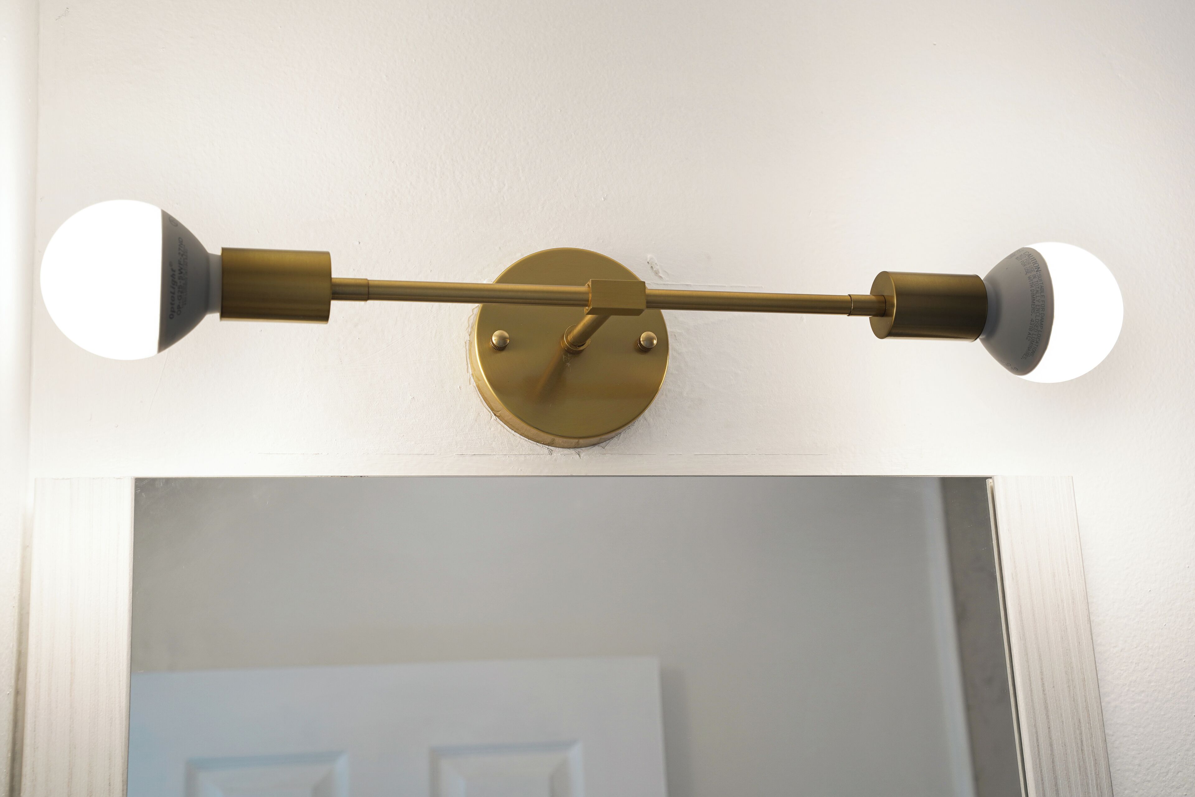 A ceiling-mounted light fixture with two spherical bulbs and a central control mechanism.