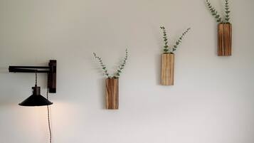 A wall-mounted pendant light and three wooden planters with green foliage.