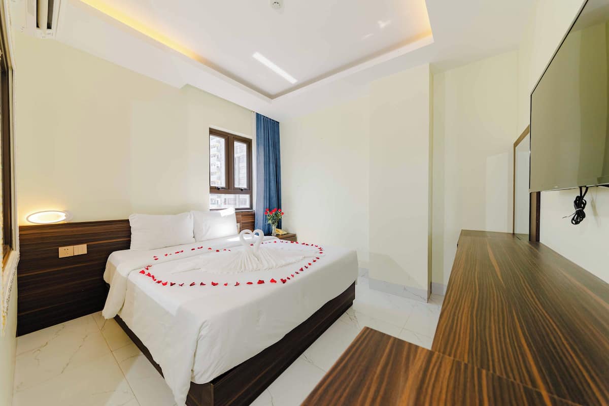 Ein Hotelzimmer mit Bett, Nachttisch und einem großen Spiegel.