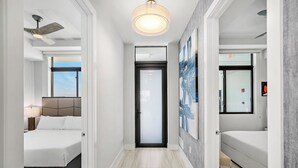 A modern hotel room with a bed, a desk, a ceiling fan, and a large window. - Hi3051hl202: 3 Bed, Ocean Breeze (Melbourne Beach)