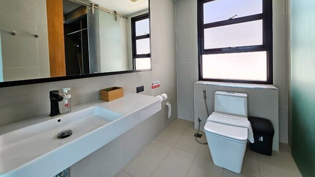 A modern bathroom with a white sink, mirror, and toilet. - 8IK88 Resort (Pa Klok)