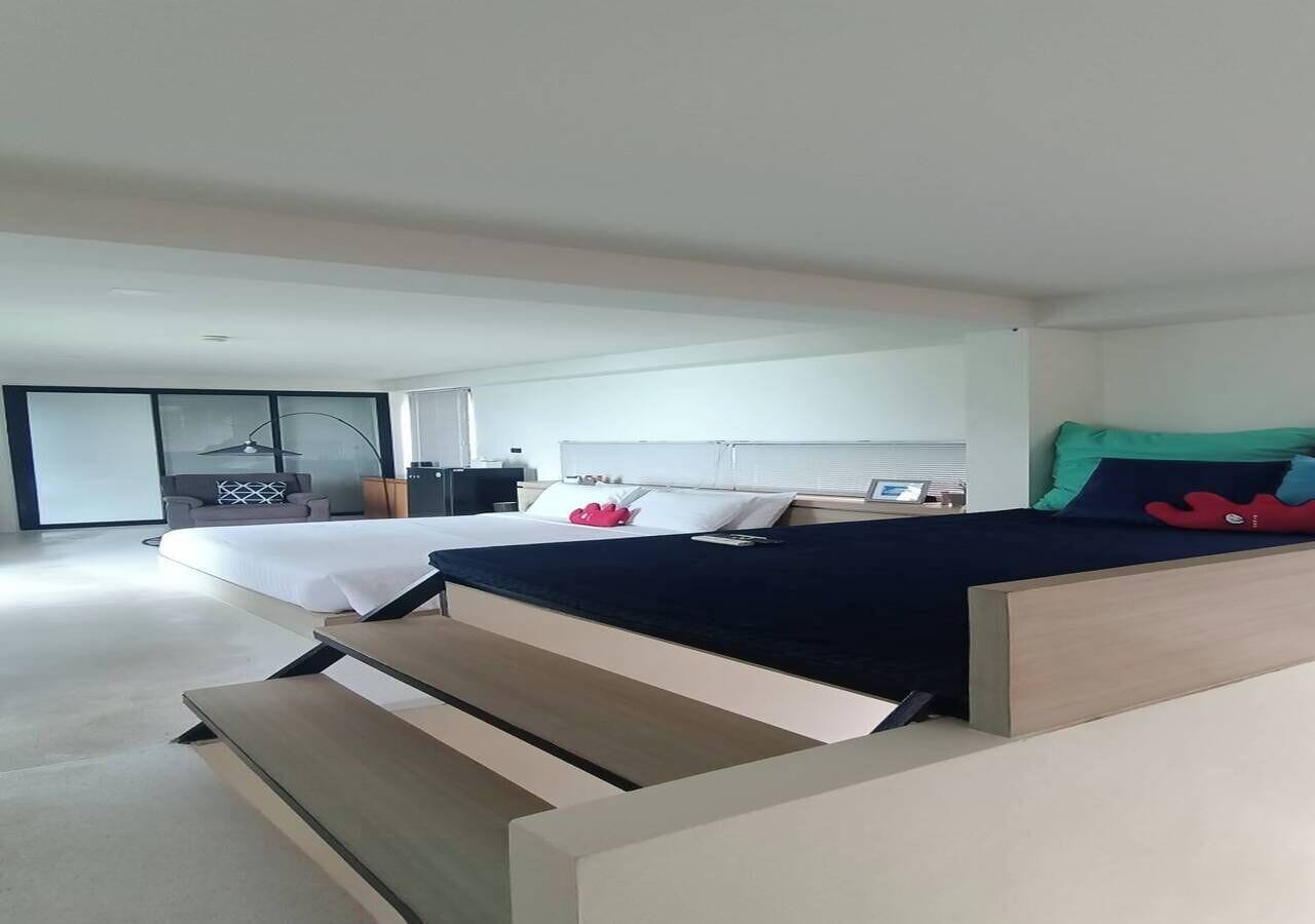 A modern bedroom with a bed, a desk, and a chair.