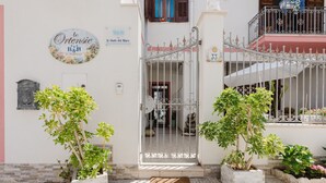 A gated entrance with a wrought iron gate, potted plants, and a doormat. - Bed and Breakfast 'Le Ortensie Verde' with Shared Terrace, Wi-Fi and Air Conditioning (San Vito Lo Capo)