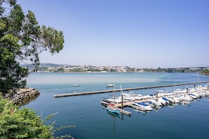 Un port de plaisance avec des bateaux amarrés, une eau calme et une vue lointaine sur la ville.