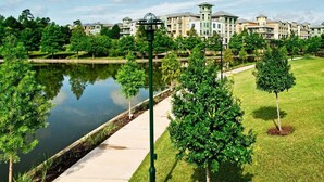 Zona residencial com um lago, gramados verdes e edifícios modernos com varandas.