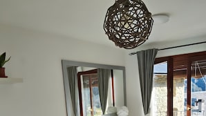 Ein Wohnzimmer mit Sofa, einem kleinen Tisch, einem Schreibtisch und einem Balkon mit Blick.
