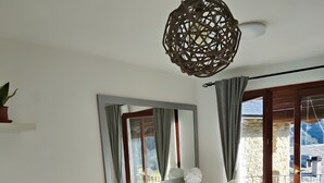 Ein Wohnzimmer mit Sofa, einem kleinen Tisch, einem Schreibtisch und einem Balkon mit Blick.