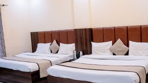 A hotel room with two beds, a ceiling fan, recessed lighting, and a marble floor. - Hotel Shivay Palace (Agra)