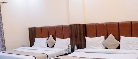 A hotel room with two beds, a ceiling fan, recessed lighting, and a marble floor.
