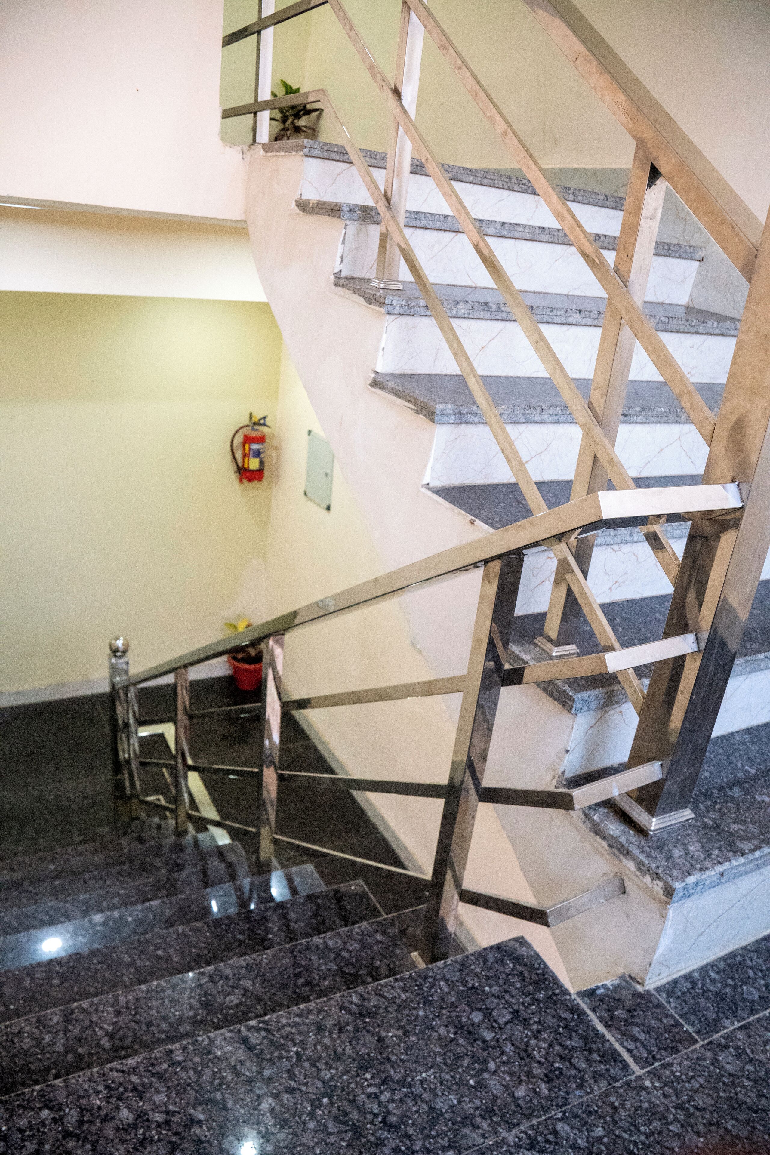 A staircase with a metal handrail and marble steps.