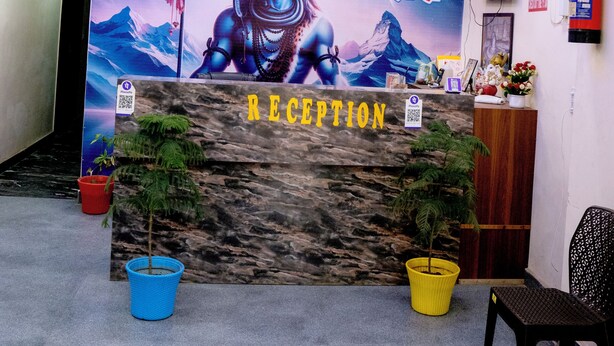 A reception area with a mural of a deity, a reception desk, and potted plants. - Hotel Shivay Palace (Agra)