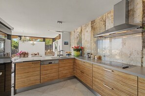 Una cocina moderna con muebles de madera, lavavajillas integrado y una isla grande con fregadero.