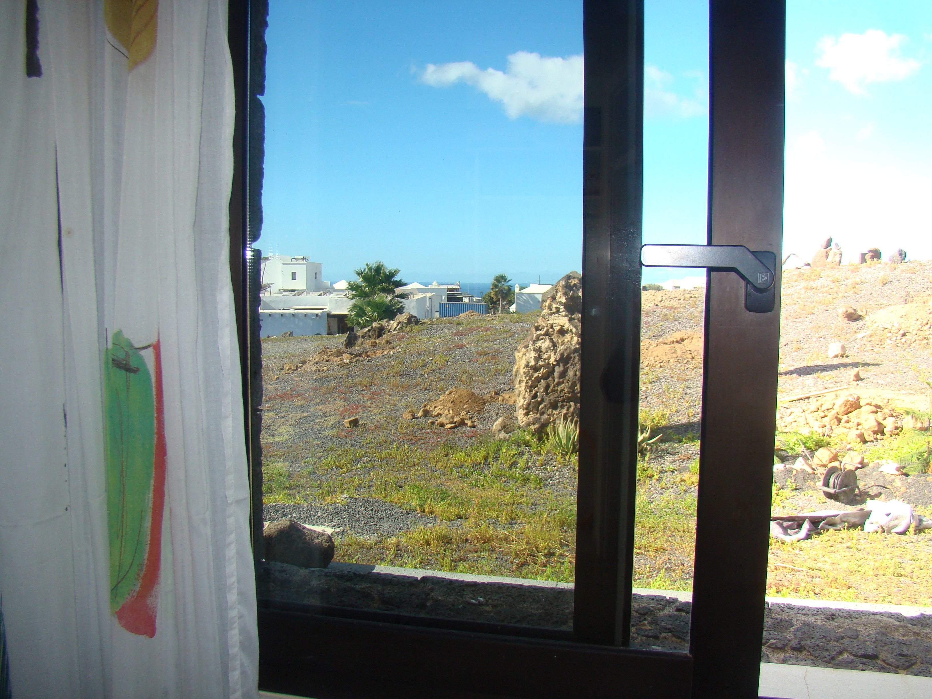 Blick aus dem Fenster auf eine felsige Landschaft mit blauem Himmel.