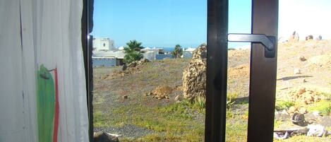 A window view of a rocky landscape with a clear sky.