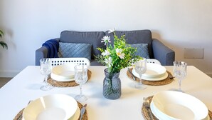 A dining table set with plates, cutlery, and glasses, with a vase of flowers in the center. - Smeralda by Interhome (Valledoria)