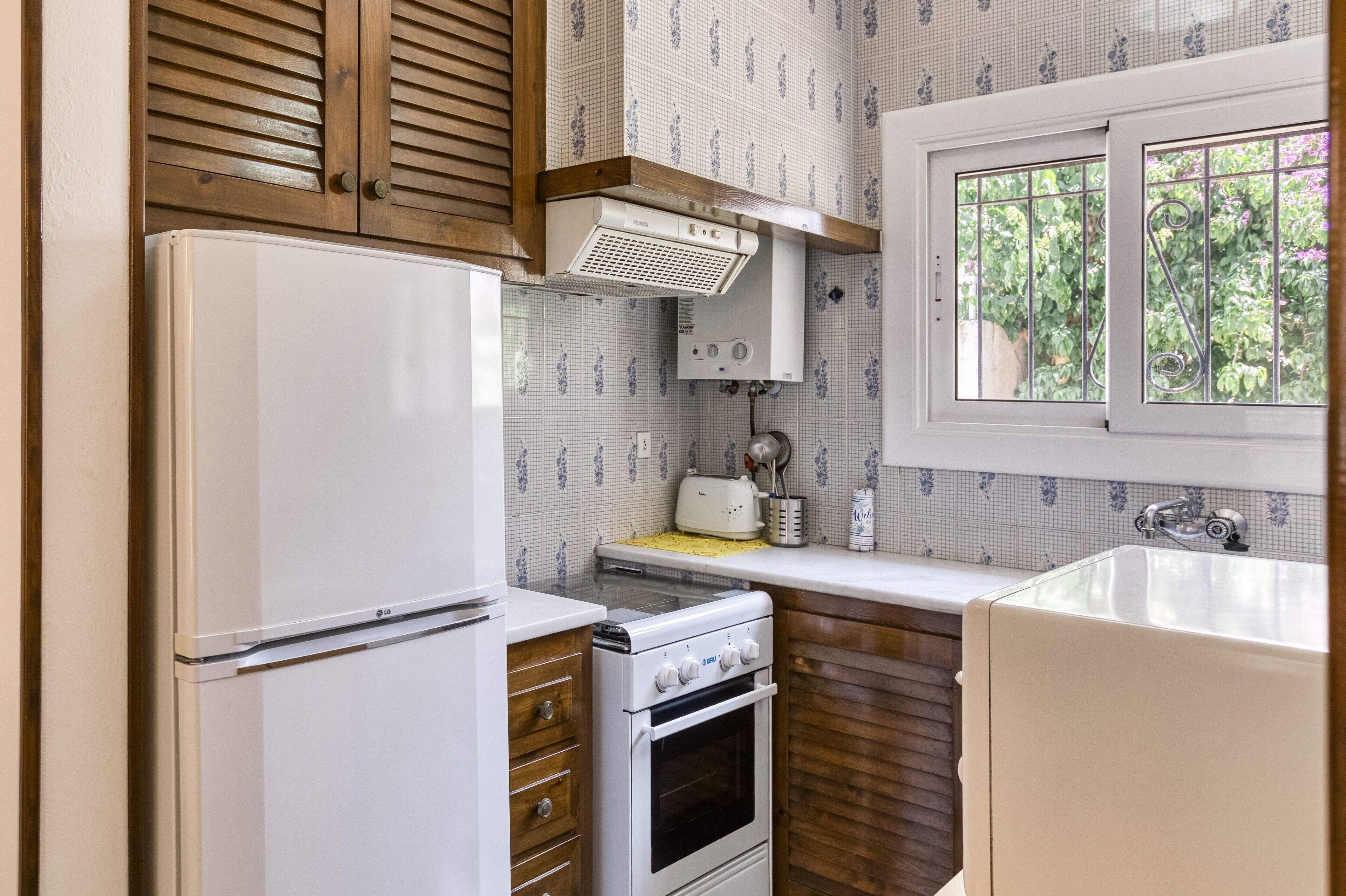 A compact kitchen with a refrigerator, stove, and sink.