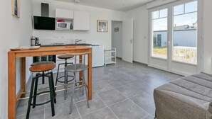 Una cocina moderna con comedor, sofá y puerta corrediza de vidrio que da a un patio exterior.