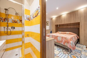 A bathroom with a shower, a toilet, and a sink.