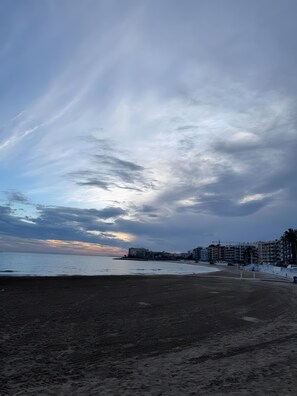 Una playa con edificios al fondo.
