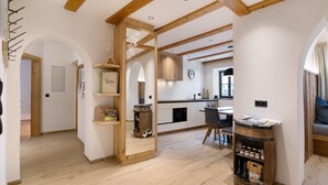 A modern kitchen with wooden beams, a built-in wine rack, and a dining area with a table and chairs.