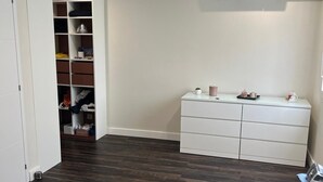 A bedroom with a bed, a dresser, a wardrobe, and an air conditioning unit. - QUIET HOUSE (Cuxac-d'Aude)