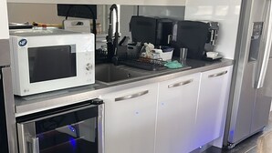 A modern kitchen with white cabinets, a built-in microwave, a stainless steel refrigerator, and a compact oven. - QUIET HOUSE (Cuxac-d'Aude)