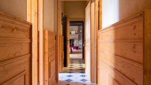 Un pasillo con paneles de madera y un suelo estampado que conduce a una habitación con chimenea.