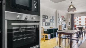 A kitchen with a built-in oven, a dining area with a table and chairs, and a hanging light fixture. - Apartment 'Rincon Del Arenal' with Sea View, Wi-Fi and Air Conditioning (Platja de l'Arenal)