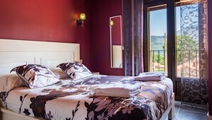 Une chambre avec un grand lit, une fenêtre donnant sur un beau paysage et un miroir.