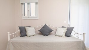 A bed with a white metal frame, a beige bedspread, and three pillows. - Apartment 'Mantisses Studio' with Shared Terrace, Wi-Fi and Air Conditioning (?a?aµ?ta)