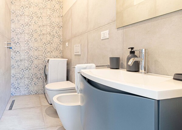 A modern bathroom with a shower, toilet, and sink.