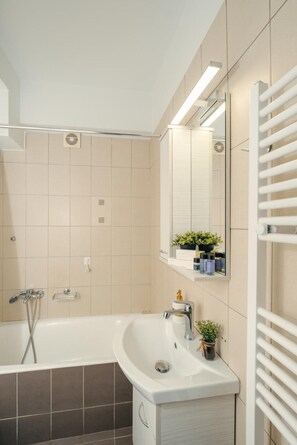 A modern bathroom with a bathtub, sink, and mirror. - Apartment 'Mantisses 4 Studio' with Balcony, Wi-Fi and Air Conditioning (?a?aµ?ta)