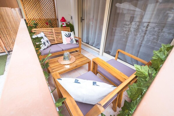 A balcony with wooden furniture, a cushioned bench, and a glass door. - Apartment 'Mantisses 4 Studio' with Balcony, Wi-Fi and Air Conditioning (?a?aµ?ta)