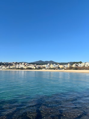 A coastal cityscape with buildings along the shoreline and a clear blue sky. - Apartment 'Portblanc' with Balcony, Wi-Fi, and Air Conditioning (Arenys de Mar)