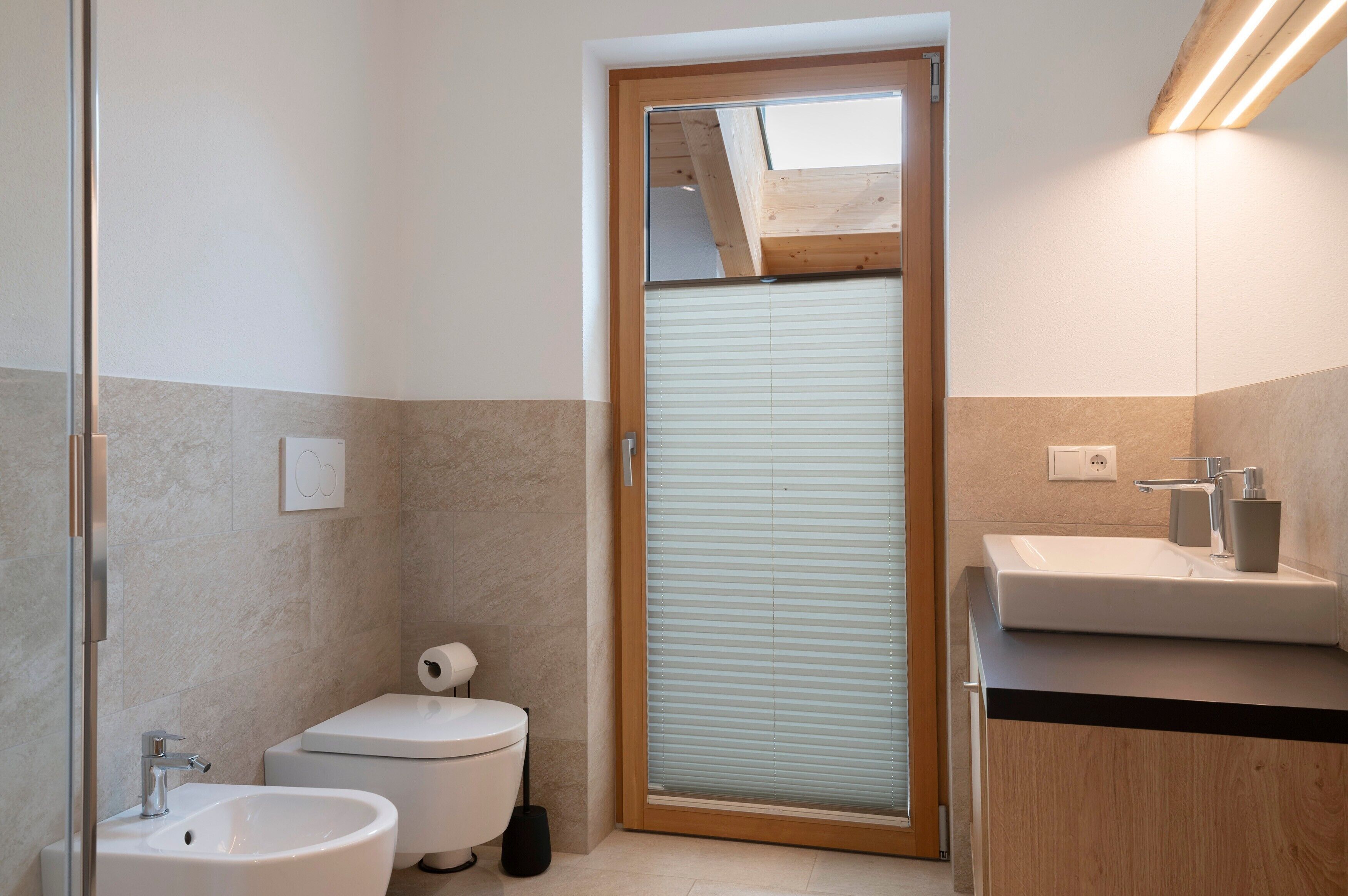 Ein modernes Badezimmer mit Toilette, Bidet und Waschbecken.
