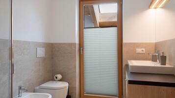 Ein modernes Badezimmer mit Toilette, Bidet und Waschbecken.