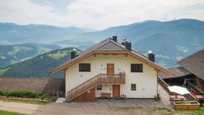 A house with a balcony, a door, and a window. - Apartment 'Sunset' with Mountain View, Private Terrace and Wi-Fi (St. Lorenzen)