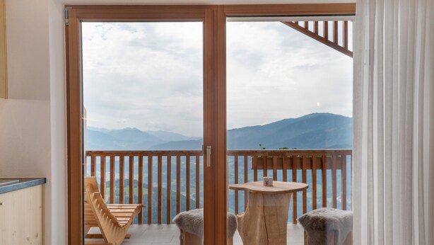 A room with a sliding glass door leading to a balcony with a view of mountains. - Apartment 'Sunset' with Mountain View, Private Terrace and Wi-Fi (St. Lorenzen)