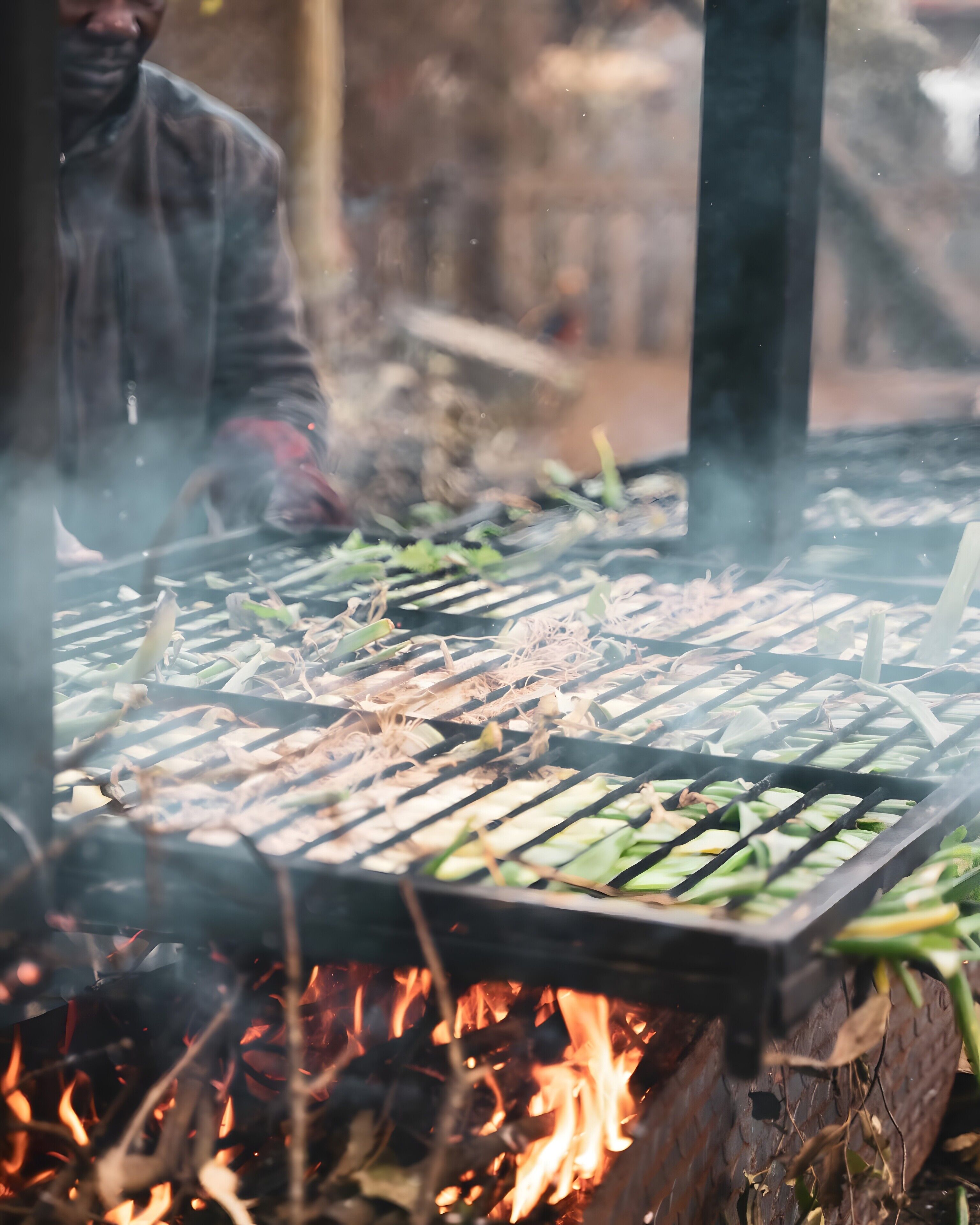Una parrilla con alimentos cocinándose sobre fuego abierto.