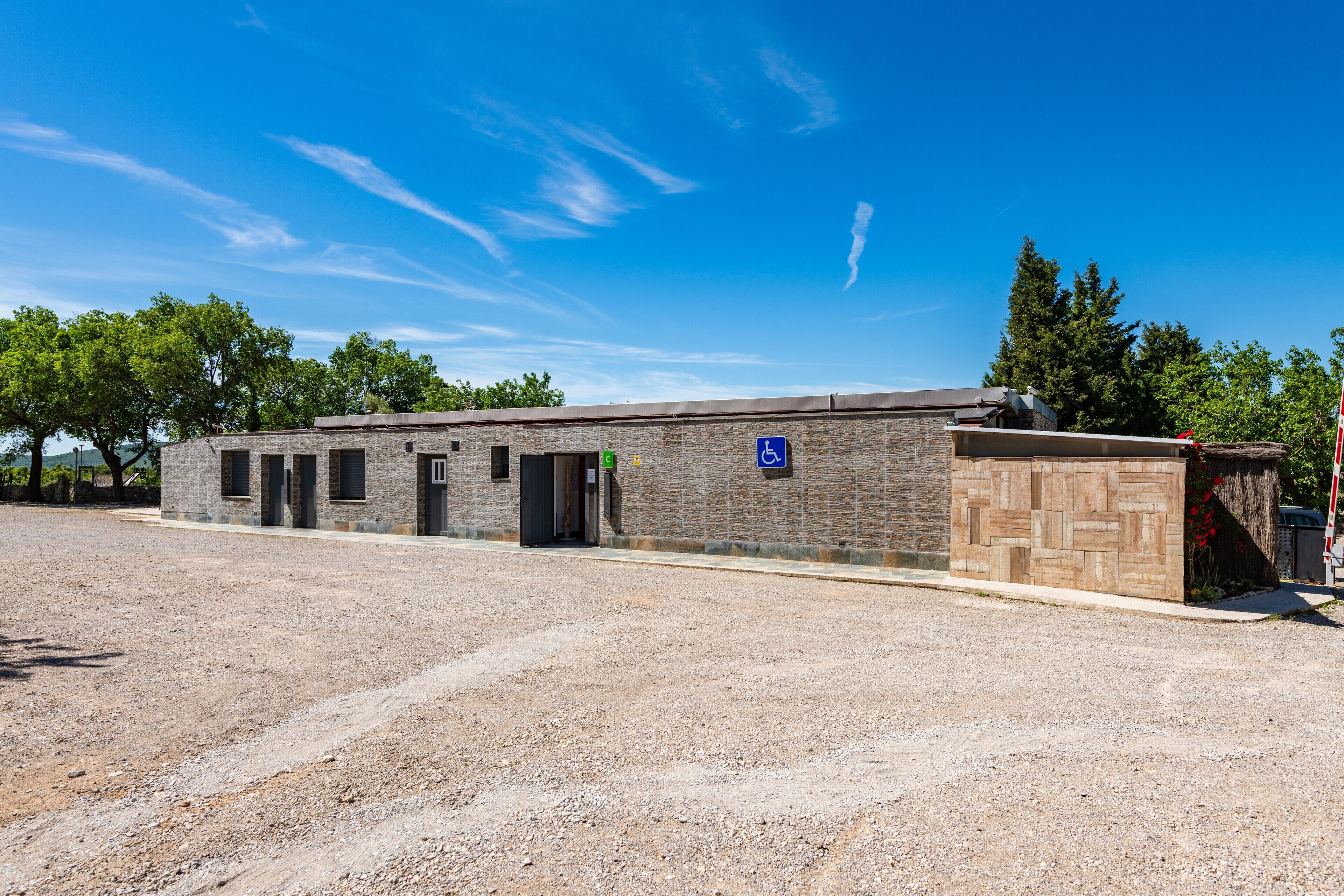 Un bâtiment à la façade en briques, doté de plusieurs portes et d’un panneau indiquant qu’il est accessible aux personnes handicapées.
