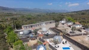 A resort with multiple spherical structures, a swimming pool, and a view of distant mountains. - Mobile Home '243' with Mountain View, Wi-Fi and Air Conditioning (Tírig)